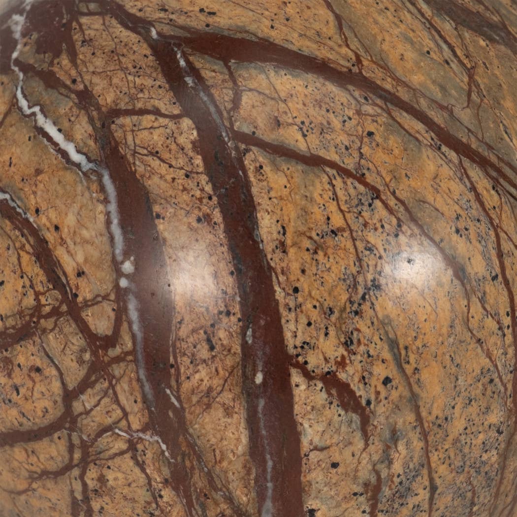 Close-up of brown marble sphere showing dark natural veining