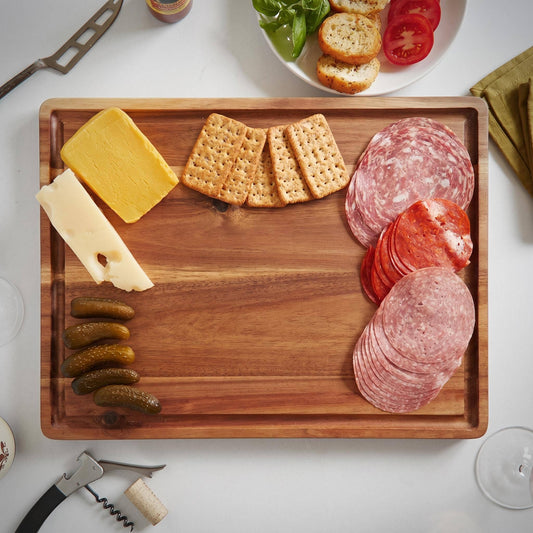 	Close-up of an acacia charcuterie board with sliced meats, cheese, and crackers