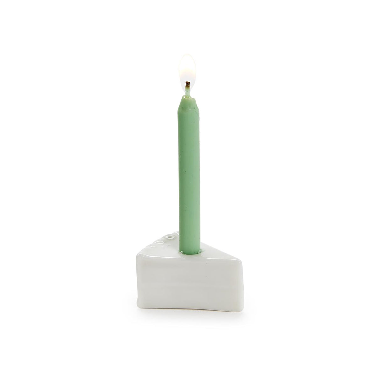 Tiny porcelain cake slice candle holder with lit green birthday candle