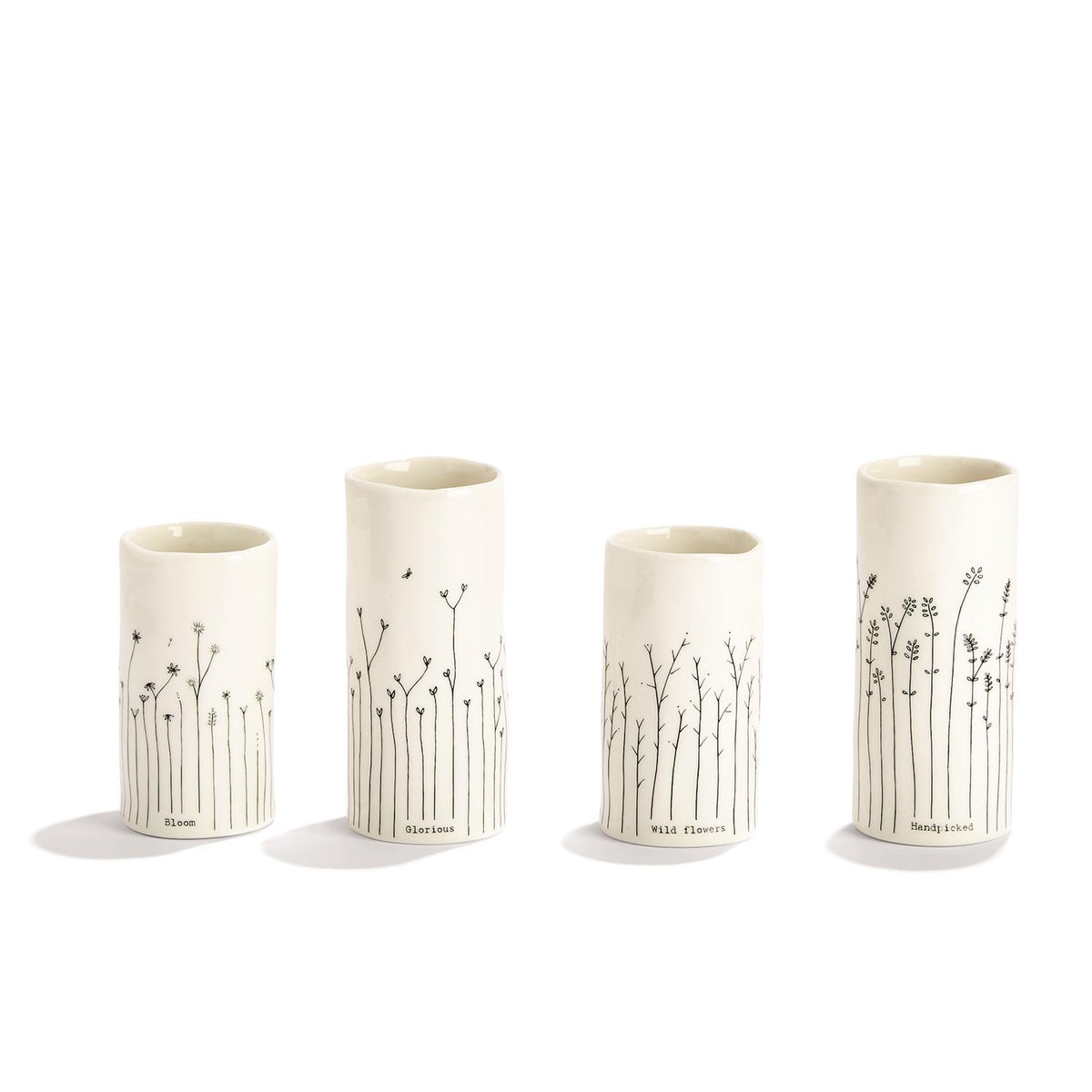 Four white porcelain bud vases of different heights with hand-drawn black botanical line designs