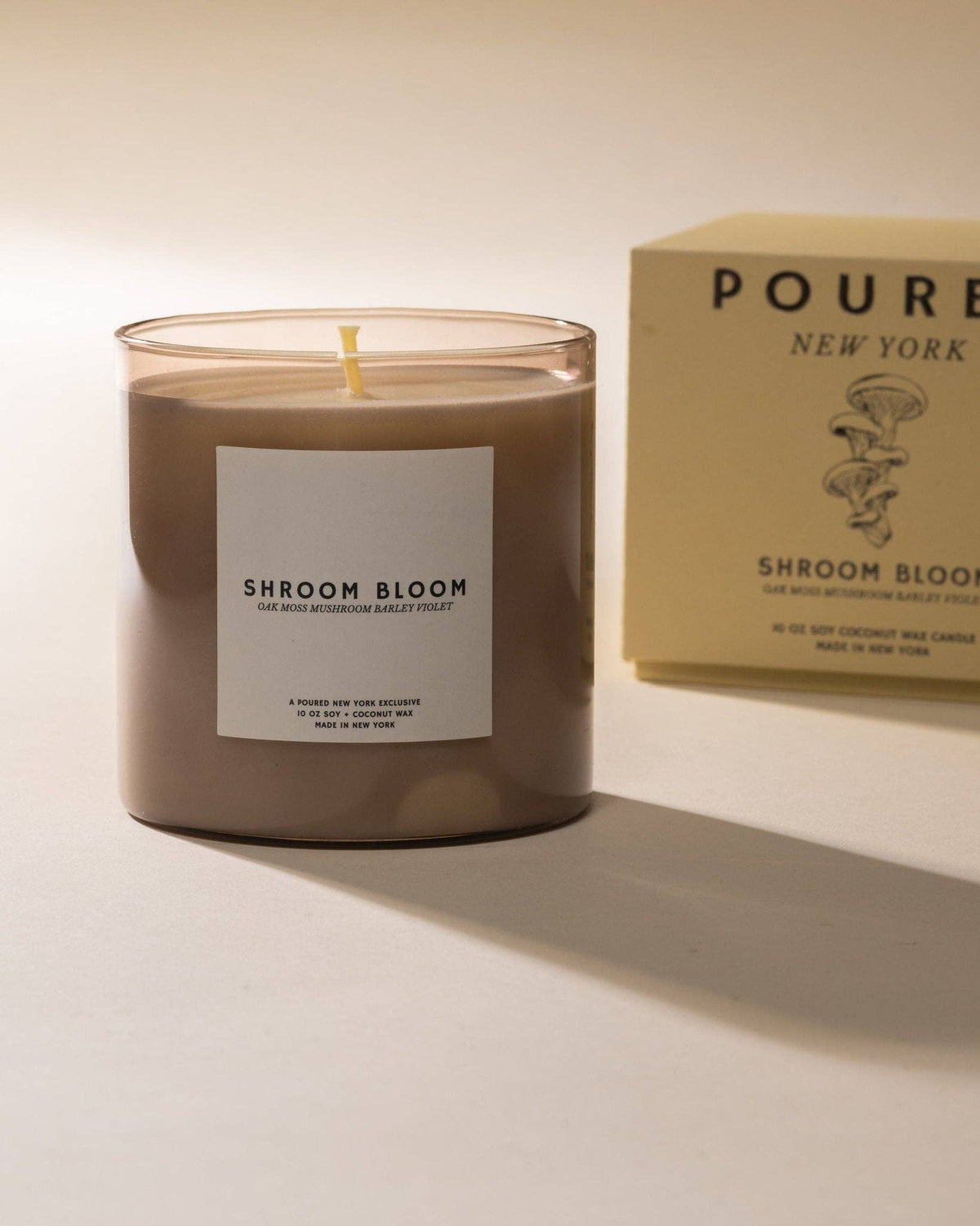 Shroom Bloom candle in a brown glass jar next to its cream Poured gift box