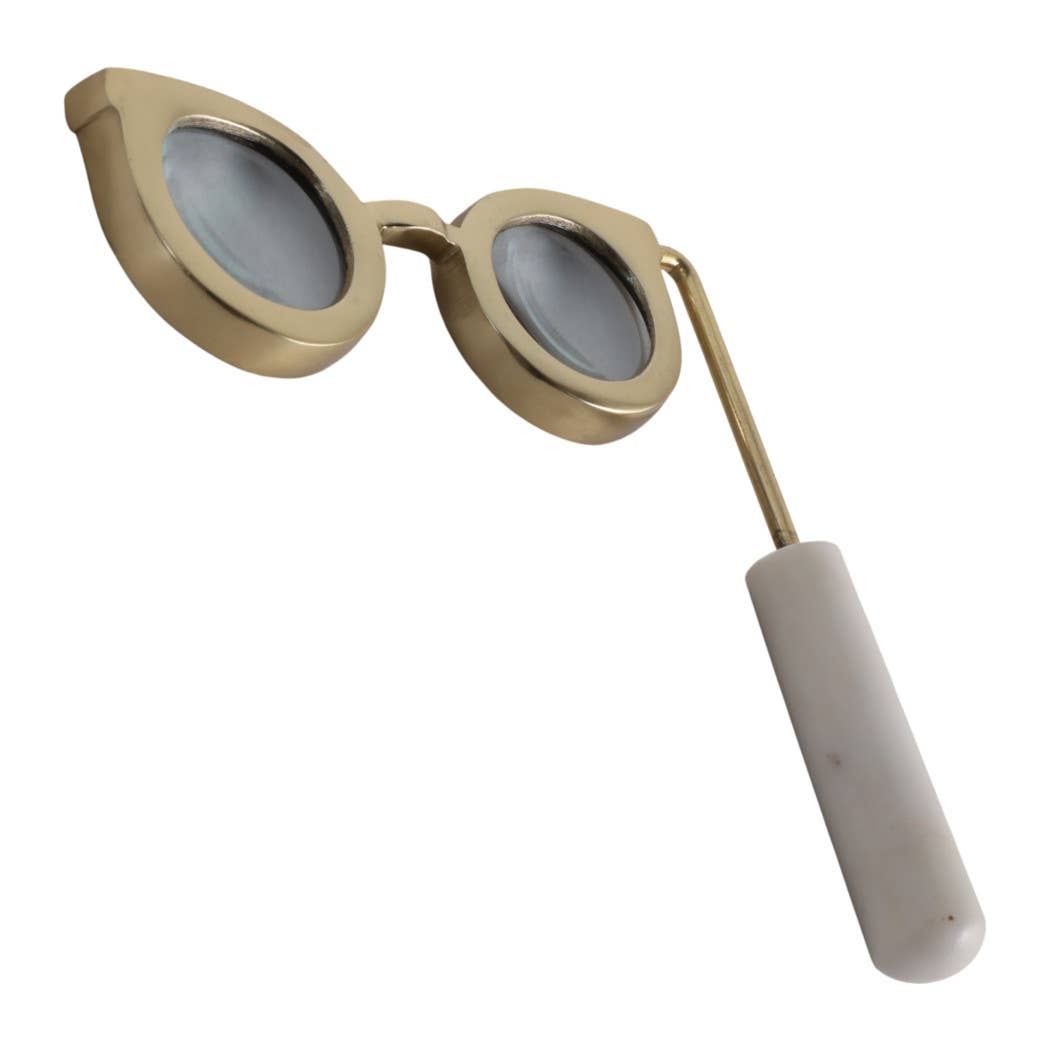 Gold eyeglass-shaped magnifying glass with white marble handle, angled view