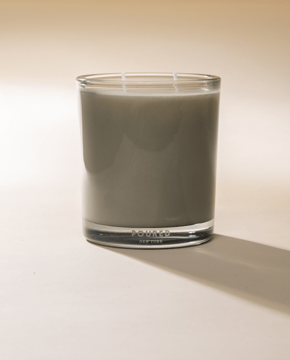 Noud Bois candle in a tinted glass tumbler, side view