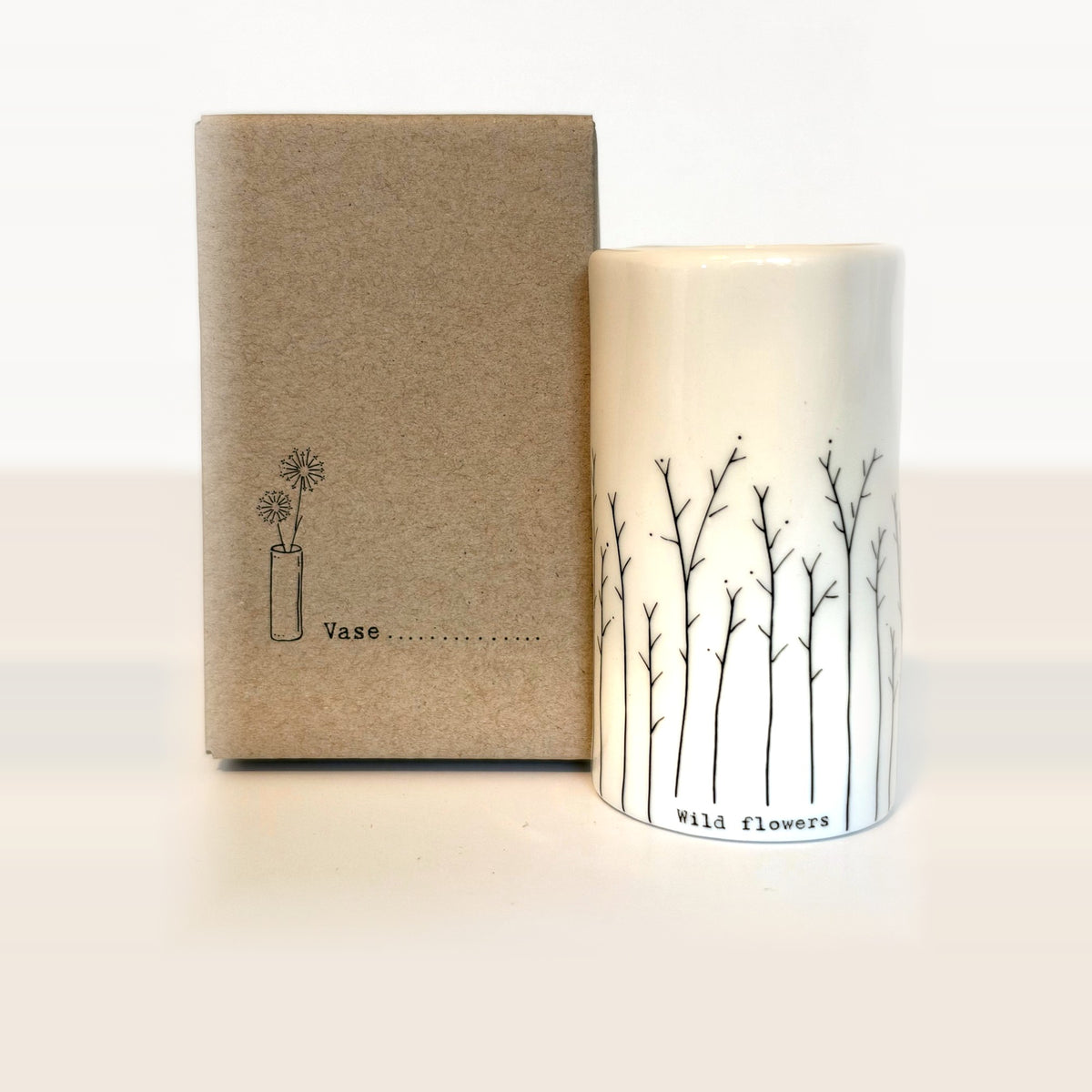 Wild flowers mini porcelain vase with hand-drawn branching stems next to its kraft gift box