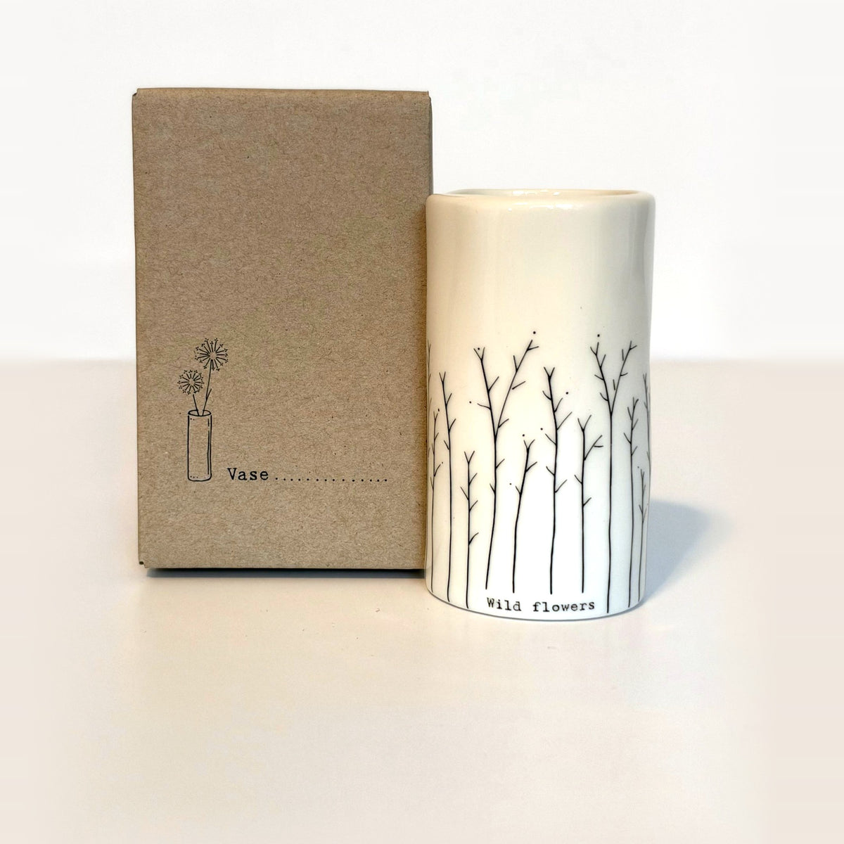 Wild flowers mini porcelain vase with hand-drawn branching stems next to its kraft gift box
